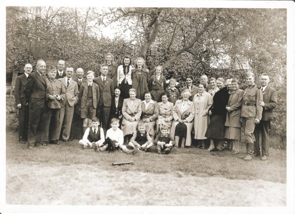 Lehrerfamilien 1940: Das Oerlinghauser Kollegium traf sich in der Freizeit. Roland Ploeger sitzt links vorn im Gras. Neben ihm Gunther Diekmann. Stehend (v. li.) die Herren Plöger (Vater), Stecker, Holzkamp (in Uniform) , Hunke, Elbracht, Husemann. In der Mitte sitzend die Damen Plöger, Wittenberg, Möller, NN. Daneben stehend Frau Holzkamp, Frl. Schäfermeyer, Frl. Tölle. Ganz rechts Hermann Diekmann, der seinen ältesten Sohn Horst (in Uniform) im Arm hält – der übrigens kurz darauf gefallen ist. - © Repro: Horst Biere / Quelle: Arc