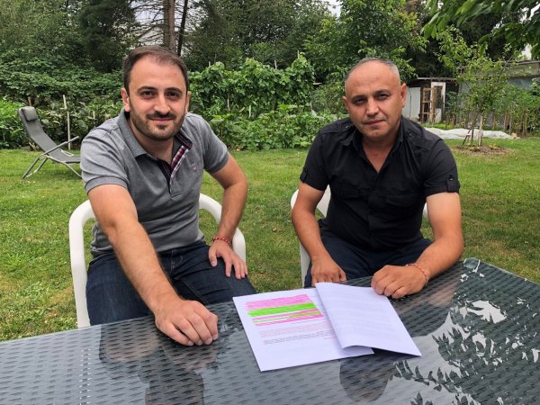 Hacar Hasan (links) und Milad Acar sitzen im Garten von Hasan, vor ihnen liegt das Konzept, das sie für die Festhalle Schötmar ausgearbeitet hatten. - © Sven Kienscherf