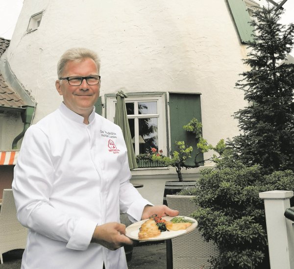 Holger Lemke präsentiert die Lachsforelle auf der Sonnenterrasse der Windmühle. - © Anke Groenewold