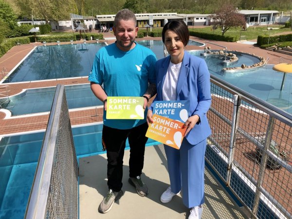 Marco Schubert (stellvertretender Betriebsleiter) und Anna-Lisa Davidovic (Abteilungsleiterin Unternehmenskommunikation Stadtwerke) stehen auf dem Sprungturm im Bega-Bad und zeigen das Design der neuen Saisonkarten. Foto: Sven Kienscherf - © Sven Kienscherf