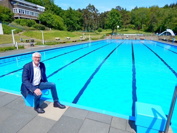 Stadtwerkechef Peter Synowski, der auch für die Bäder zuständig ist, sitzt auf einem der Startblöcke, hinter sich das 50 Meter lange Schwimmerbecken. - © Gunter Held