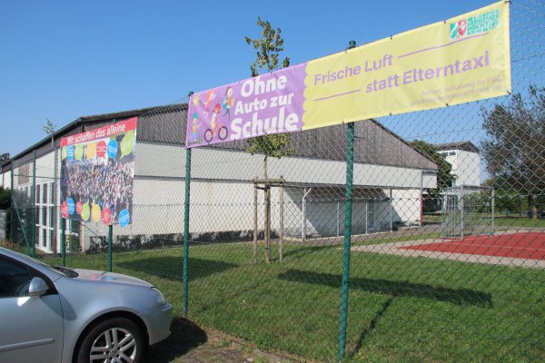 Die Grundschule In der Senne macht bereits mit Transparenten Eltern darauf aufmerksam, dass ihre Sprösslinge auch mal ein paar Meter zu Fuß gehen können und nicht mit dem Auto bis vor den Eingang gebracht werden müssen. - © Dieter Asbrock