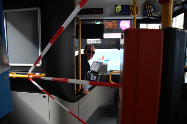 Hinter den rot-weißen Absperrbändern schaut Fahrer Andreas Teichrib in den Bus. Mit seinen Fahrgästen hat er derzeit nur wenige Gespräche. Zu groß ist der Sicherheitsabstand. - © Katrin Kantelberg
