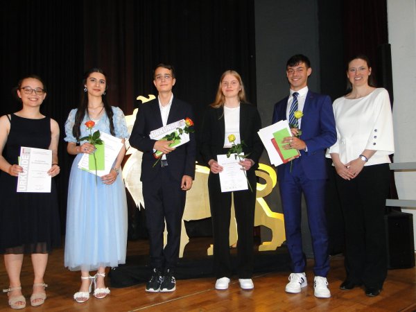 Schulleiterin Dr. Alexandra Nolte (rechts) hebt fünf Schüler in der Abitur-Entlassfeier für Spitzenleistungen hervor. Stellvertreter für Dutzende von Absolventen, die sich in vielen Fächern und Bereichen des schulischen Lebens besonders hervorgetan haben sind Lea Peter (von links), Lilaw Hussein, Luis Mateo Grobler, Lena Kuhlmann und Elia Noam Nestoris. - © Hajo Gärtner