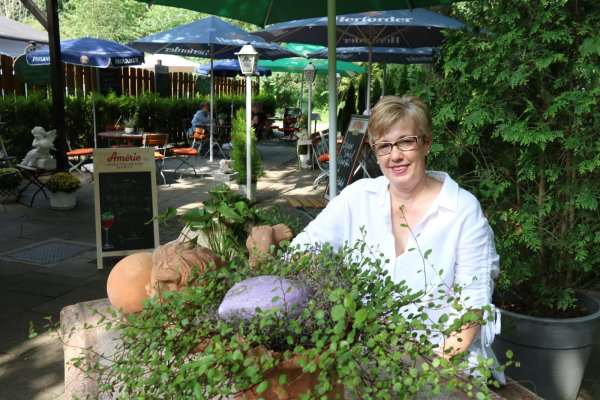 Alexandra Schulten-Kroos sitzt im Biergarten des familiengeführten Restaurants "Zur Loose". - © Alexandra Schaller