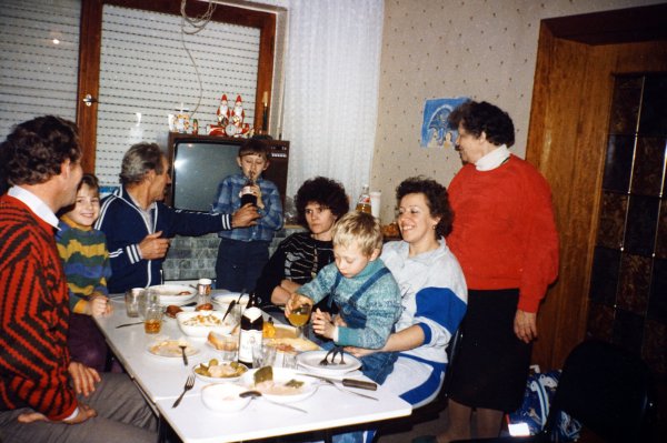 Das Foto zeigt ein gemeinsames Essen in einer Notwohnung im Jahr 1992. - © Museum für russlanddeutsche Kulturgeschichte