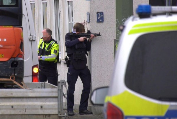 Dieses Bild kursiert in sozialen Medien: Der Polizist zielt um die Ecke, jedoch fehlt das Magazin seiner Waffe. Dafür gibt es jedoch eine Erklärung. - © Christian Müller/TV7news/dpa