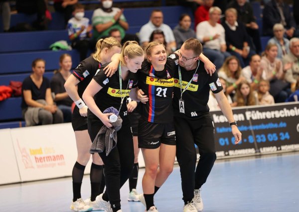 Gestützt von Physiotherapeutin Christin Schürmann und vom Mannschaftsverantwortlichen Oliver Lippert geht es für Blombergs verletzte Spielerin Nele Franz vom Spielfeld auf die Bank und anschließend in die Kabine. - © Paul Cohen