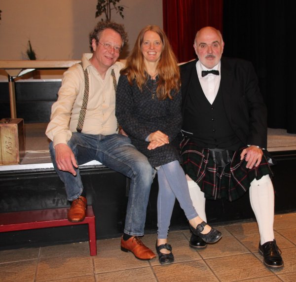 Die britische Krimi-Nacht im Bürgerhaus hat dem Publikum gefallen: Die Autoren Robert C. Marley (links) und Joachim H. Peters rahmen Shankari Susanne Hill ein, die den musikalishen Teil bestritten hat. - © Michael Biermann