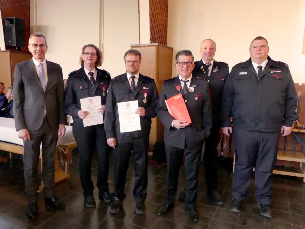 Leiter der Feuerwehr Mike Mundhenke (rechts) und Bürgermeister Jörg Bierwirth (links) gratulieren den Geehrten, die der Wehr schon viele Jahre die Treue halten. - © Rudi Rudolph