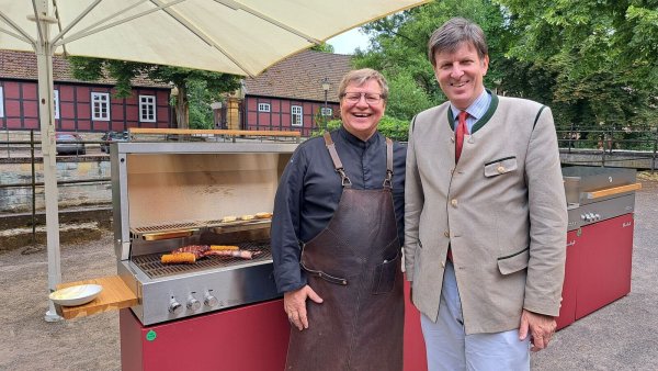 Sven Schurig (l.) und Maximilian Fürst zu Bentheim-Tecklenburg mit Maiskolben und einem Rib-Eye Steak auf dem Grill. - © Marion Pokorra