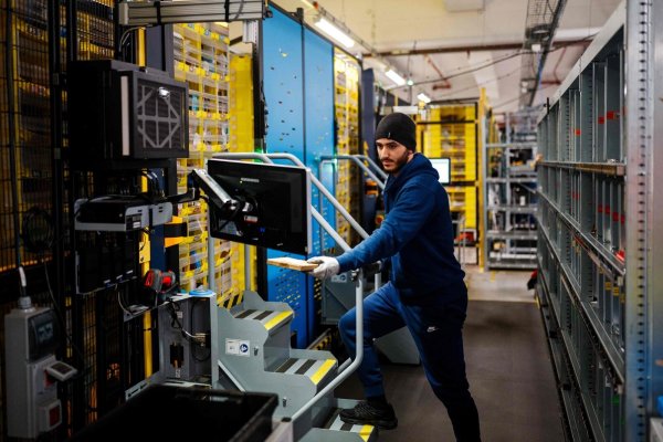 Ein Mitarbeiter kümmert sich um Pakete an einem Logistikstandort von Amazon. - © AFP or licensors