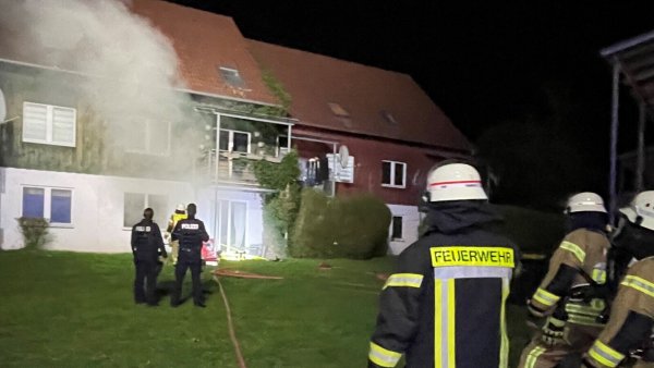 Vor dem Mehrfamilienhaus an der Kolberger Straße stehen zahlreiche Einsatzkräfte. In der Erdgeschosswohnung ist ein Feuer ausgebrochen. Die Bewohner waren zum Glück nicht zu Hause. - © Daniel Hobein/Feuerwehr Bad Salzuflen