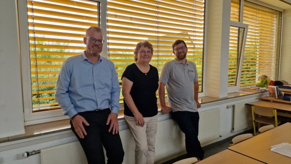 Bürgermeister Friso Veldink (von links), Gemeindemitarbeiterin Ingrid Behlen und Stephan Rohde von der beauftragten Firma sitzen vor dem umgebauten Sonnenschutz in einer Klasse der Grundschule Ost in Humfeld. - © Nadine Uphoff