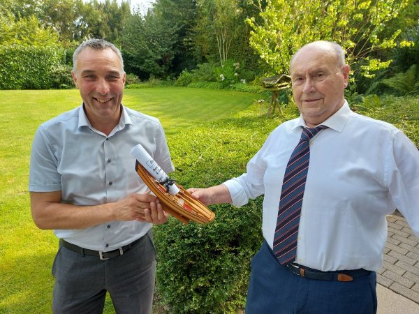 Hans-Georg Wüllner (rechts) überreicht Bürgermeister Dirk Tolkemitt ein prall gefülltes Modellboot. - © Stadt Bad Salzuflen