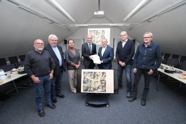 Die Umgestaltung des Langenholzhauser Mühlenvorplatzes kann kommen: Jens Kronsbein von der Bezirksregierung Detmold (Vierter von links) übergibt Kalletals Bürgermeister Mario Hecker im Rathaus das Dokument, das 454.000 Euro wert ist. Mit dabei sind (von links) SPD-Fraktionsvorsitzender Manfred Rehse, der zweite stellvertretende Bürgermeister Volker Preuß (CDU), Bauamtsleiterin Ewa Hermann (Grüne), der stellvertretende Bürgermeister Dieter Hartwig (SPD) und Stefan Pohl vom Bauamt. - © Jens Rademacher