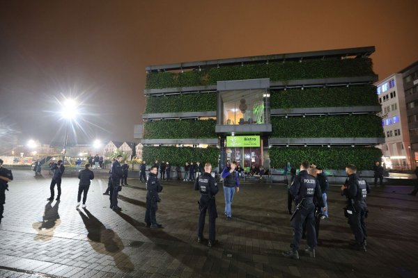 Die Polizei hat eine Gruppe Menschen am grünen Würfel umzingelt. - © Oliver Krato