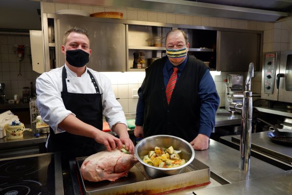 Küchenchef Florian Grönnert (links) und Geschäftsleiter Norbert Lange mit einer der Gänse, die für den Außer-Haus-Verkauf vorbereitet wird. Neben Privatleuten beliefert das Team auch Unternehmen und eine Kita. - © Lorraine Brinkmann