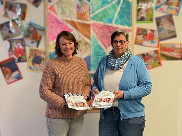 Einen Stapel von Broschüren überreicht Vanessa Mohnke (links) an die Leiterin der Marianne-Frostig-Kindertagesstätte der Lebenshilfe Detmold, Marina Wiegand. - © EUTB