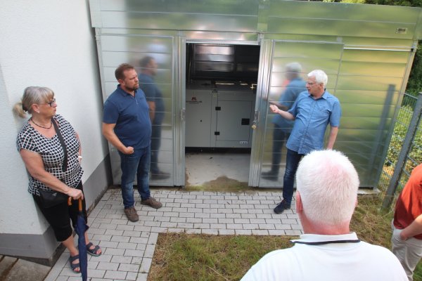 Ernst-Joachim Gerke vom Wasserwerk der Gemeinde Kalletal zeigt Mitgliedern des Betriebsausschusses das neue Notstromaggregat am Trinkwasserbrunnen in Brosen. - © Jens Rademacher