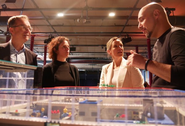 Günter Korder (v. l.), Rebecca Steinhage, Kirsten Thommes und Roman Dumitrescu sprechen über den KI-Einsatz in OWL über einem Modell, das Einsatzmöglichkeiten zeigt. - © Jemima Wittig