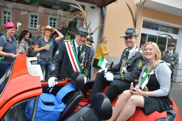 Robin Grote (links) hat den Umzug für das Königspaar Sebastian Boer und Christiane Hoffmann organisiert. Im roten VW-Käfer Cabrio geht es durch die Stadt. - © Karin Prignitz