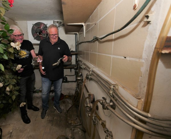 Im ehemaligen Kühlraum, der sich direkt hinter der Theke befand, sind noch die alten Zuleitungen für die Zapfhähne zu sehen. Hartmut Topp (links) und Arno Bulau finden noch zwei alte Zapfhähne. - © Jost Wolf