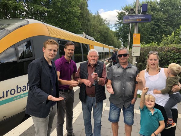 Symbolisch zücken (von links) Janik Wiemann, Steffen Buttler, Günter Wiemann, Thomas Burkert und Vanessa Lessow mit Jonte und Bjarne (stehend) ihr Kleingeld. Als Hörstmaraner haben sie nichts von den Gratis-Fahrten des Stadtbusses. Denn die Eurobahn, die gerade im Hintergrund stoppt, hält sich aus der Werbeaktion raus - © Till Brand