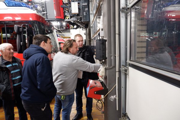 Gert Graf (von links), Klimaschutzmanager Yannic Hausmann, Michael Wehrmann und Andreas Ens schauen sich die Schwachstellen in der Feuerwache Bösingfeld an. Durch die undichten Tore geht viel Energie verloren. - © Lorraine Brinkmann