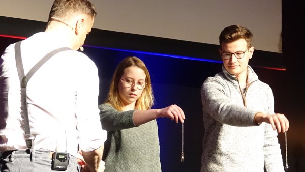 Pendeln nur mit der Kraft der Gedanken: Lars Ruth (links) und seine Gäste auf der Bühne. - © Axel Bürger