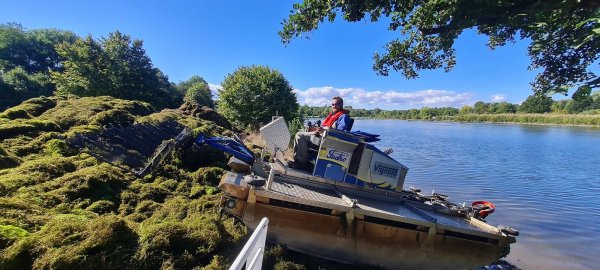 In seinem Amphibienfahrzeug bringt Kevin Weidenhagen von der Firma Vignold Gewässerpflege aus Essen die Reste der Kanadischen Wasserpest an Land. Dort holt sie der Betreiber einer Biogasanlage ab. - © Marianne Schwarzer