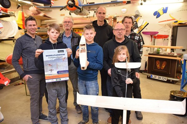 Sebastian Stenzel (von links), Lukas, Dietmar Friedrich, Alfred, Axel Schubert, Willi Kobuß, Linus und Klaus Hensel weisen in der Werkstatt der Modellbauer auf die nächste Veranstaltung am 8. März hin. Foto: Karin Prignitz - © Karin Prignitz