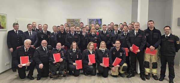 Die anwesenden Beförderten und Geehrten der Lügder Wehr mit dem stellvertretenden Kreisbrandmeister Sascha Medina (rechts), Bürgermeister Torben Blome (3. von links) und Marco Gröne, stellvertretender Wehrführer (vorne 2. von links). - © Rudi Rudolph