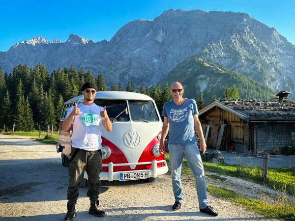 Assistent Tobi (v. l.), Bulli "Erwin" und Peter stehen an der Roßfeld-Panoramastraße bei Berchtesgaden, der höchsten mit dem Auto befahrbaren Straße in Deutschland. - © Peter Gebhard
