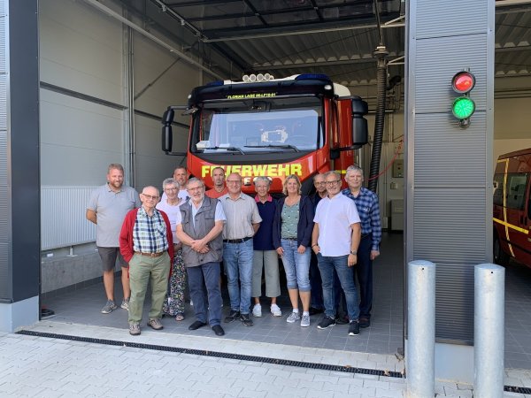 Vor der neuen Fahrzeughalle und dem Einsatzfahrzeug stehen die Teilnehmer der Veranstaltung, links Löschgruppenleiter Andreas Bicker, Zweiter von rechts Andreas Fritz, Vorsitzender des SPD-Ortsvereins Hagen/Hardissen. - © SPD