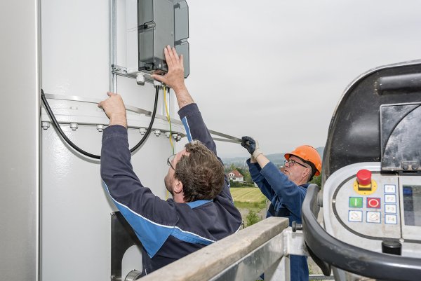 In luftiger Höhe: Marco Kirchner (links) und Gustav von Lessel installieren die Antenne am Campus.  - © Stadtwerke Lemgo/Michael Reimer
