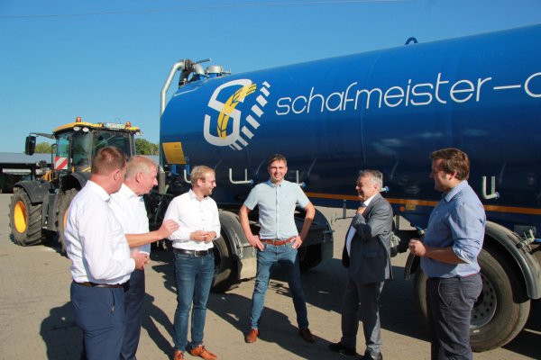 Innenminister Reul (zweitere von rechts) kommt am Donnerstagmorgen beim Agrarunternehmer Tobias Schafmeister (Mitte) in Voßheide vorbei. Mit dabei sind (von links) Klaus Hansen, Frank Meier, Borris Ortmeier und Lars Brakhage. Sie wollen Behälter, wie auf dem Foto zu sehen, für die Brandbekämpfung anmieten. - © Katrin Kantelberg