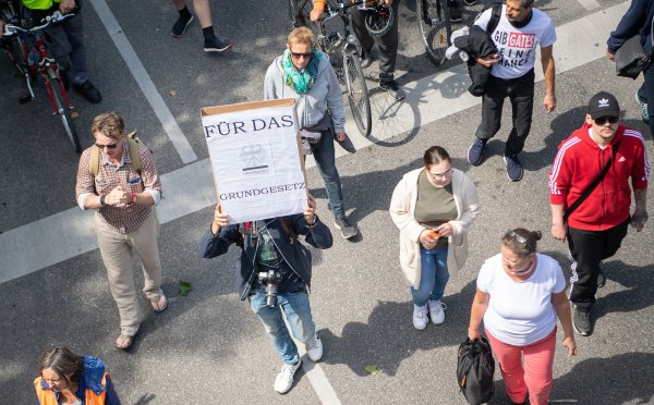 Ein Mann hält während einer Demonstration der Initiative «Querdenken 711» gegen die Corona-Maßnahmen ein Schild, auf dem «Für das Grundgesetz» steht, hoch. - © Symbolbild: Sebastian Gollnow/dpa