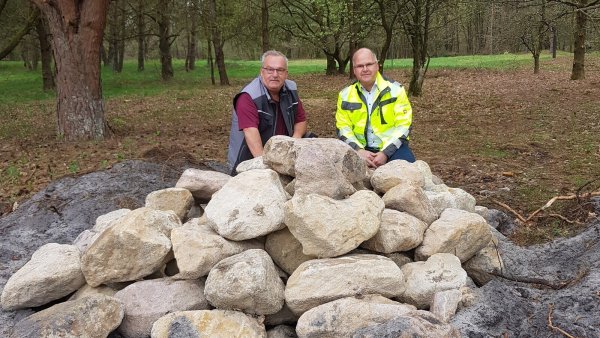Garten- und Landschaftsbauer Frank Wilhelmi (links) und Schlangens Bürgermeister Marcus Püster testen die Gemütlichkeit der neuen Steinhaufen. - © Gemeinde Schlangen