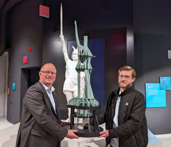 Im Hermanneum übergibt Philipp Rummeling (rechts) das Miniaturmodell der Innenkonstruktion des Hermannsdenkmals an Arne Brand (Leiter der Zentralen Infrastruktur). - © LVL