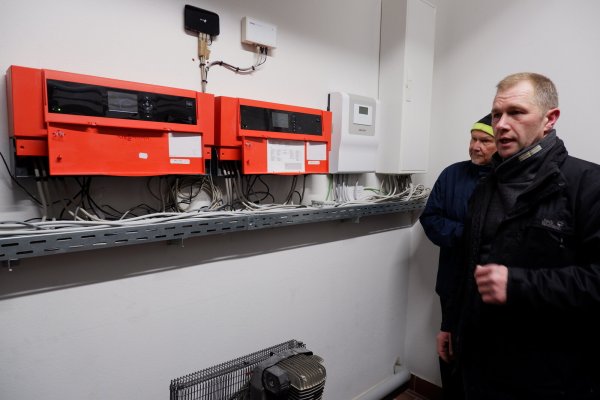 Andreas Ens, Mitglied der Energiekommission und Heizungsmonteur, erklärt die neue Anlage in der Feuerwache Silixen. - © Lorraine Brinkmann