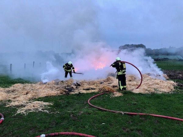 Die Feuerwehr Extertal löscht das brennende Stroh. Vorab mussten die Ballen auseinandergezogen werden. - © Löschgruppe Almena