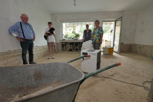 Klaus-Dieter, Jannis, Michela und Christel Düsterwald stehen in dem, was von ihrem Wohnzimmer noch übrig ist. Keller und Erdgeschoss sind auf den Stand eines Rohbaus zurückgebaut worden. - © Jost Wolf