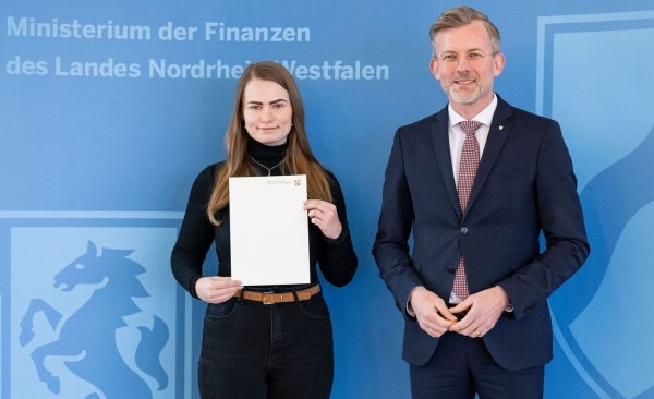 Staatssekretär Dr. Dirk Günnewig gratuliert Malin-Zoe Ehmke zur Ausbildungs-Bestnote. - © Ministerium der Finanzen / Mark Hermenau