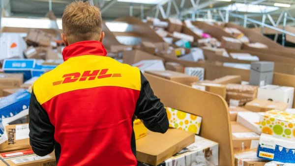 Ein DHL-Mitarbeiter sortiert Pakete in einem Logistikzentrum, um das hohe Sendungsaufkommen in der Weihnachtszeit zu bewältigen. - © DHL