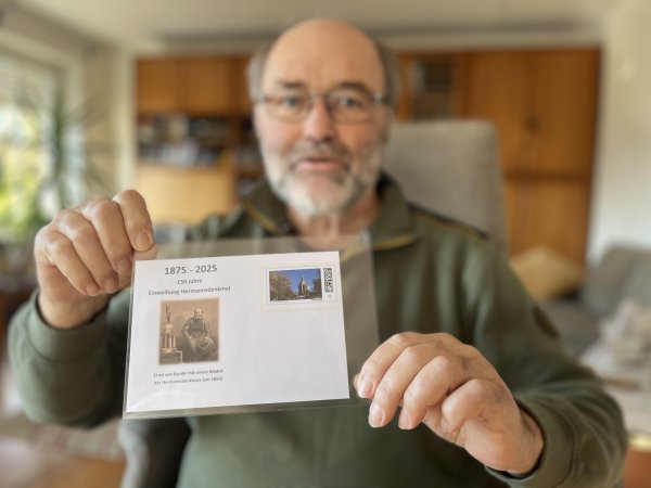Briefmarkensammler Hartmut Sohn kennt bereits den Plusbriefumschlag zum Jubiläum des Hermannsdenkmals. Rechts ist das Bauwerk, links Erbauer Ernst von Bandel zu sehen. Auch einen speziellen Stempel wird die Post auflegen. - © Till Brand