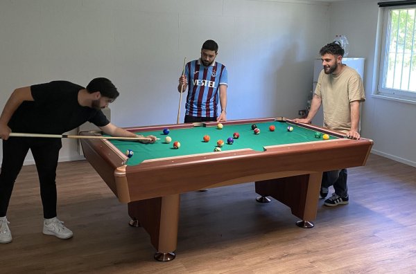 Tunahan Türker (von links), Bünyamin Cinar und Osman Aycicek testen den neuen Billardtisch im Holzfeldhaus. - © HoT Funkenflug