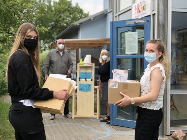 Die Masken sind da. Sarah Wollbrink (links) und Linda Lübbecke, beide Auszubildende der Stadt Lemgo, liefern Schutzausrüstung an den Montessori-Kindergarten mit Leiter Jürgen Tank und Vize Aike Overdiek. - © Till Brand