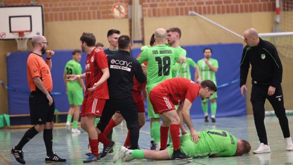 Hinter dem am Boden liegenden Jörn Seifert zoffen sich TuS-Trainer Sebastian Klaßes (Mitte) und die Spieler aus Ahmsen und Extertal. - © Paul Cohen