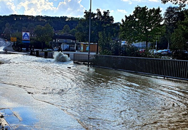 Das Wasser schießt aus dem Boden, die gesamte Straße ist großflächig überschwemmt. - © Polizei Lippe